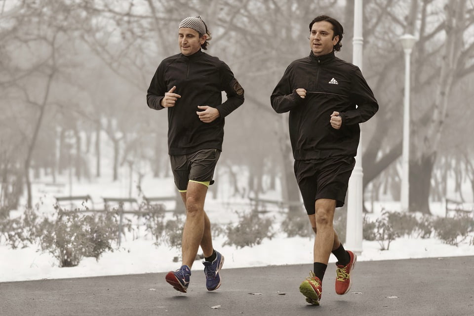 men are running in winter on the road